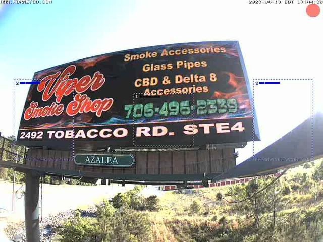 A billboard advertising a smoke shop on the side of a road
