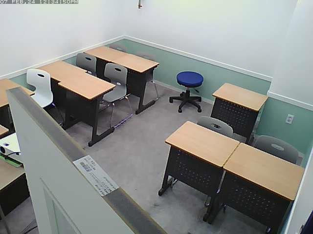 A couple of people sitting at desks in a room