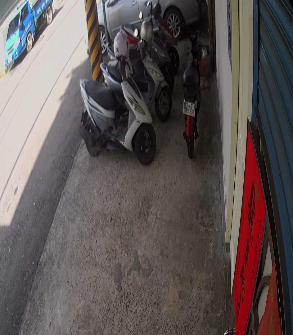 A motor scooter parked in a garage next to a wall
