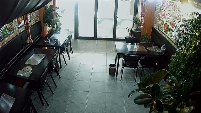 A woman standing in a restaurant looking down at the floor