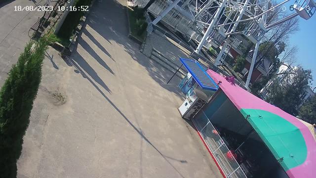 Вид с воздуха на парк развлечений с карнавальным аттракционом на заднем плане