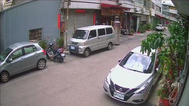 A silver van is parked in front of a building