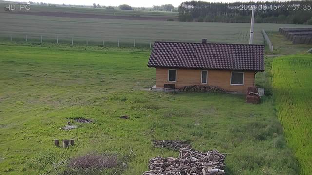 An aerial view of a small house in the middle of a field