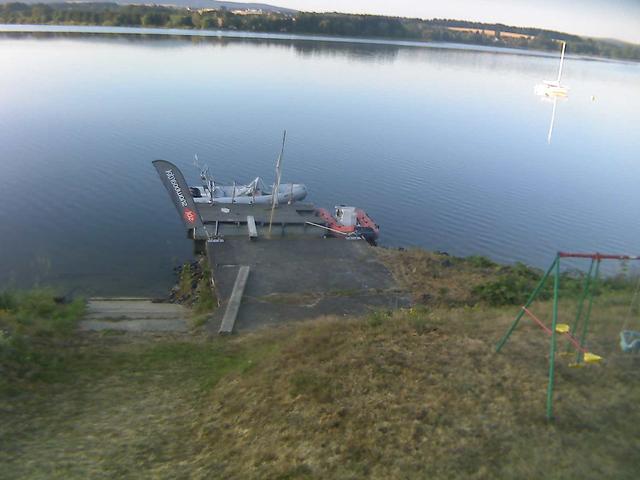A boat docked at a dock on a lake