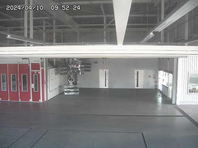 An empty garage with a red door and a red fire hydrant