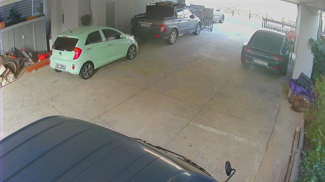 A car parked in a garage next to another car