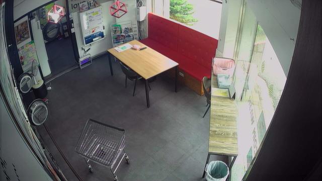 A fisheye view of a small room with a table and a shopping cart