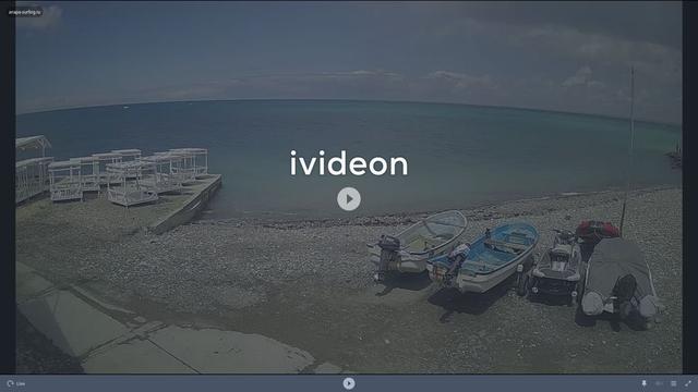 A screen shot of a beach with boats in the water