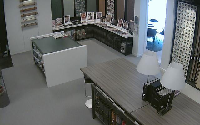 A panoramic view of a room with a desk and chairs