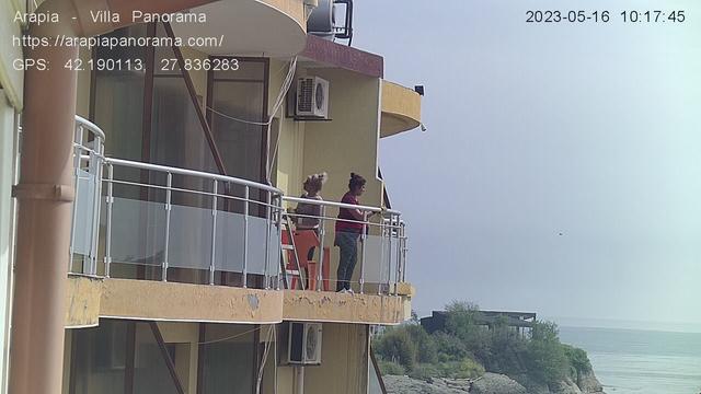 A couple of people standing on the balcony of a building