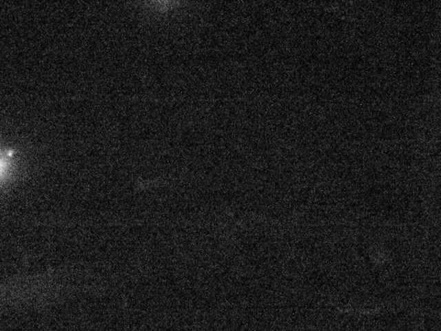 A black and white photo of a street light at night