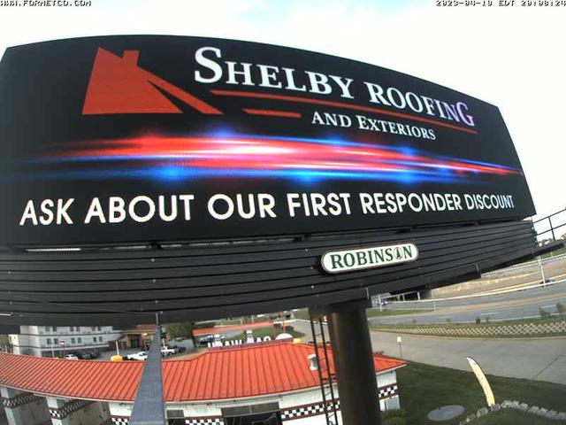 A sign for a roofing company with a sky background