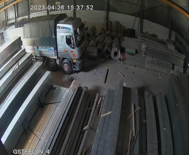 A truck parked inside of a warehouse filled with lots of metal
