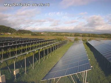 Изображение солнечной фермы с облаками на заднем плане