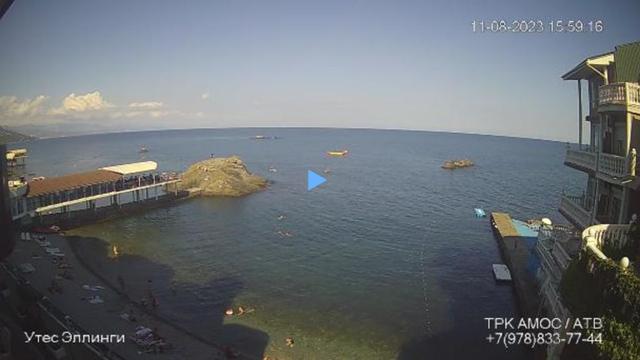 The live camera is located near the coast, showing the beach and the sea.