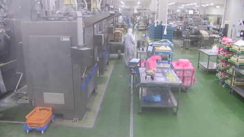 Фабрика, заполненная множеством ящиков и тележек