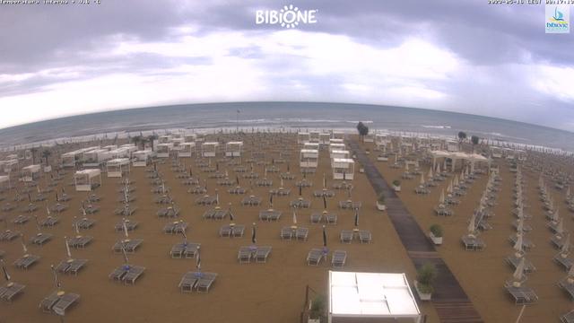 An aerial view of a beach with chairs and umbrellas