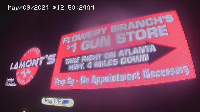 Большая вывеска, рекламирующая оружейный магазин
