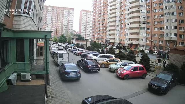 Улица, заполненная множеством припаркованных автомобилей рядом с высокими зданиями
