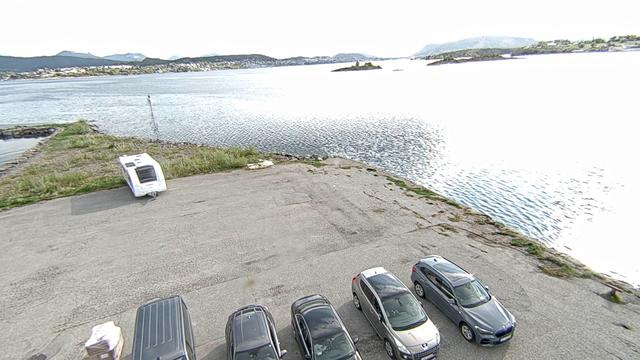 A group of cars parked next to a body of water