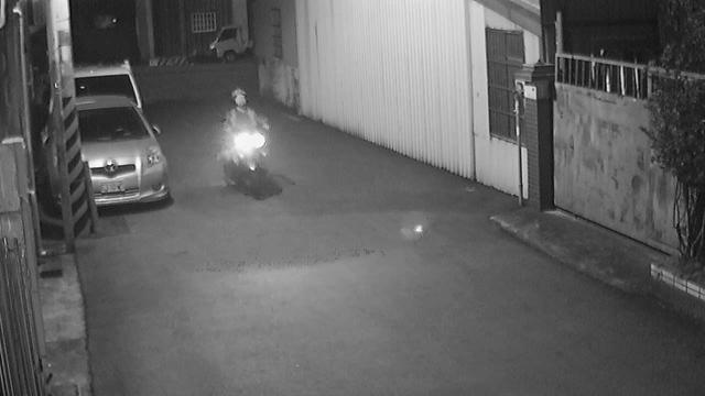 A man riding a motorcycle down a street at night