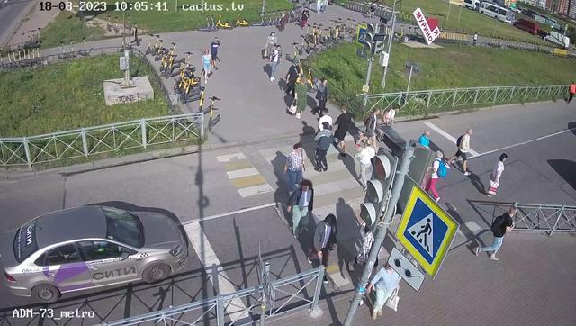 Группа людей, идущих по улице рядом со светофором