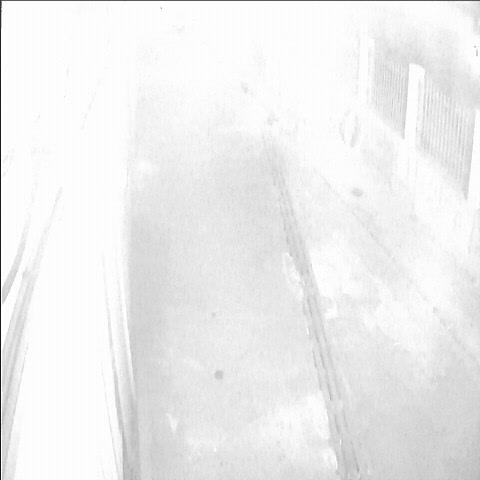 Черно-белое фото человека, идущего по коридору.