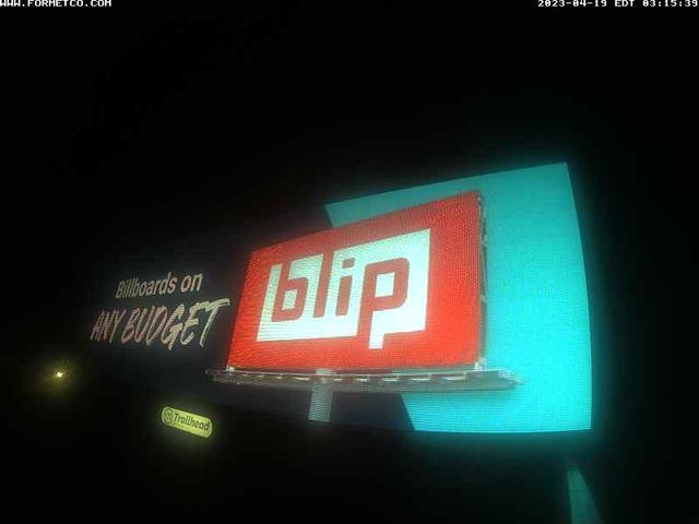 A billboard with a lit up sign in the dark