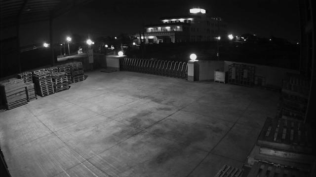 A black and white photo of a parking lot at night