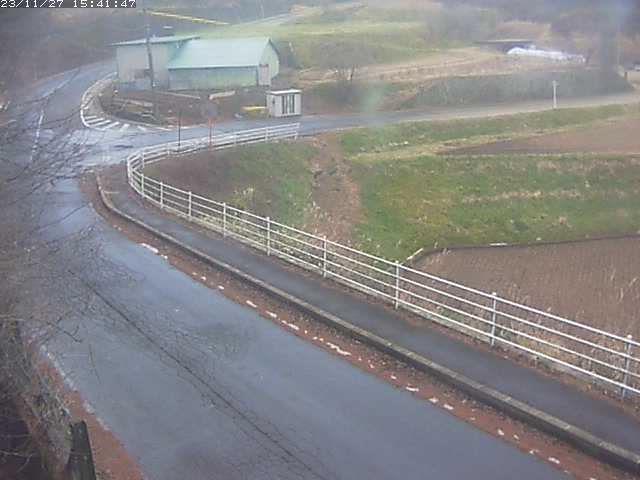 A webcam image of a road near a farm