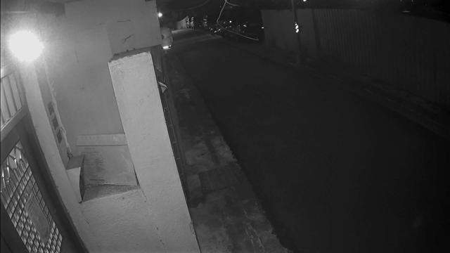 A man riding a skateboard down a street at night