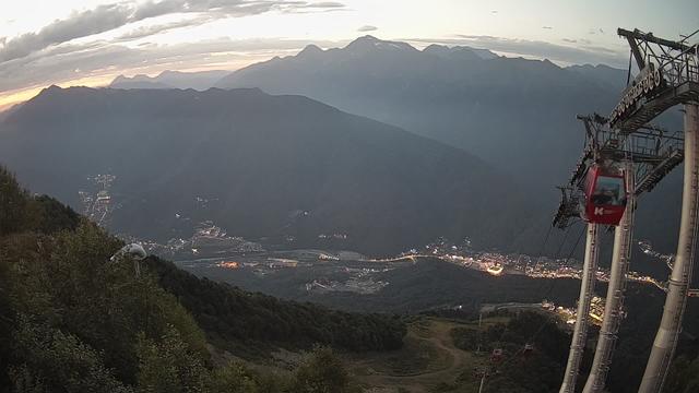 A view of a valley and mountains at sunset