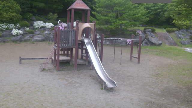 A children's playground with a slide and climbing frame