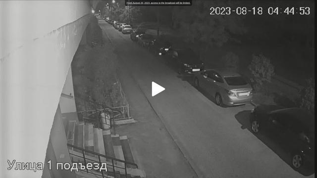 A webcam image of a street with cars parked on the side of the road