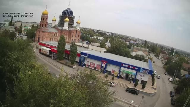 An aerial view of a train station with a church in the background