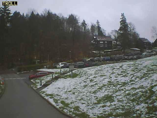 A view of a parking lot with cars parked on the side of the road