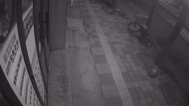 Человек, стоящий на тротуаре рядом с велосипедом