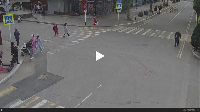 A group of people walking across a street