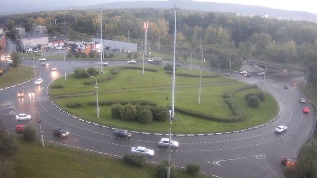 An aerial view of a roundabout with cars driving on it