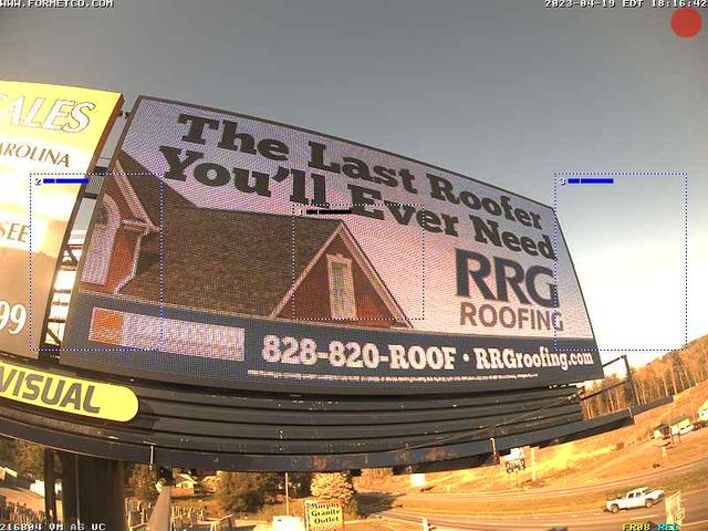 A billboard advertises a roofing company