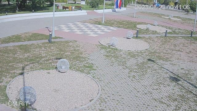 A picture of a park with benches and a checkered floor