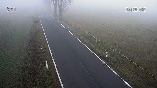 An aerial view of a road in the middle of a field