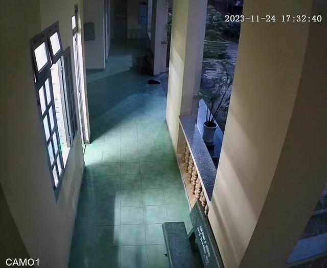 A man walking down a hallway next to a building