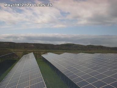 Изображение солнечной фермы с облаками на заднем плане