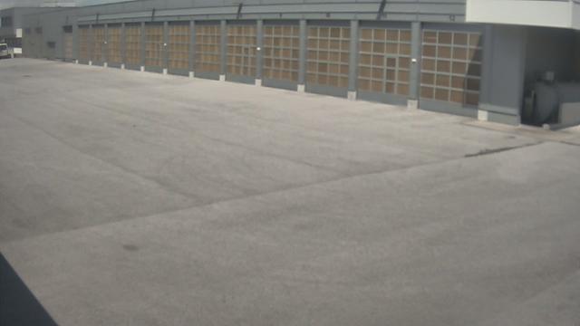 An empty parking lot with a building in the background