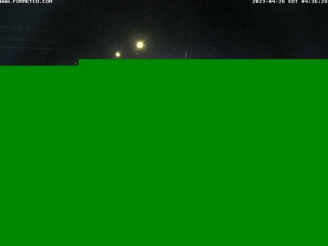 A green screen with a street light in the background