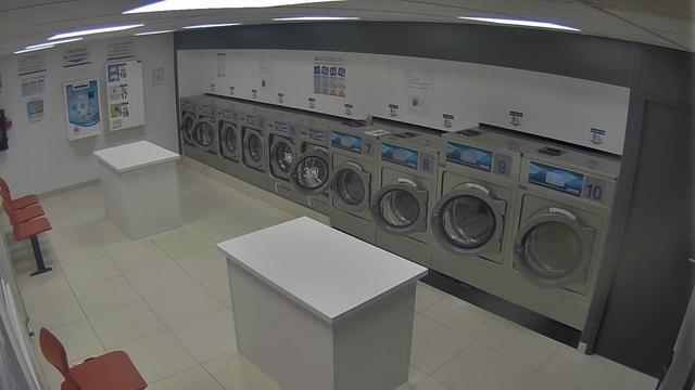 A man standing in front of a row of washing machines