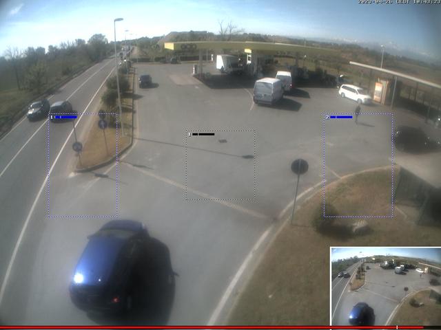 A camera view of a parking lot with cars and trucks