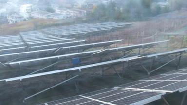 Ряд солнечных батарей на вершине поля