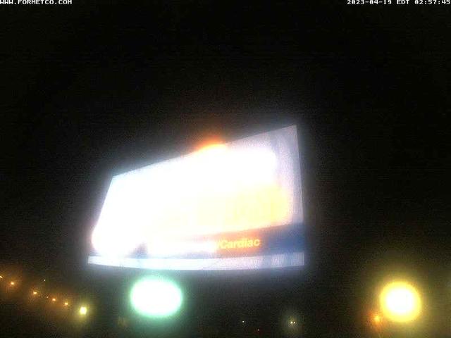 A large billboard on the side of a road at night